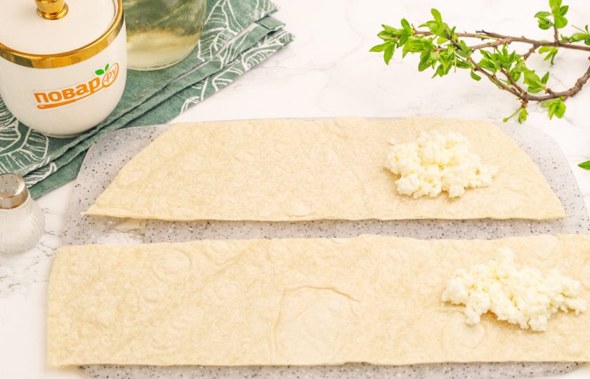 1. Этап. Лаваш с творогом в аэрогриле: Выложите на край каждой полоски по 1,5 ст.л. творожной начинки.