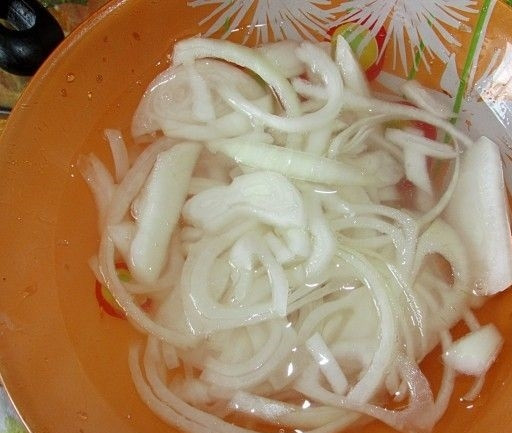 1. Этап. Салат с куриными сердечками и огурцом: 3. Пока варятся сердечки, нарежьте тонкими полукольцами лук, замаринуйте его в уксусе с водой. Добавьте щепотку соли и сахара.