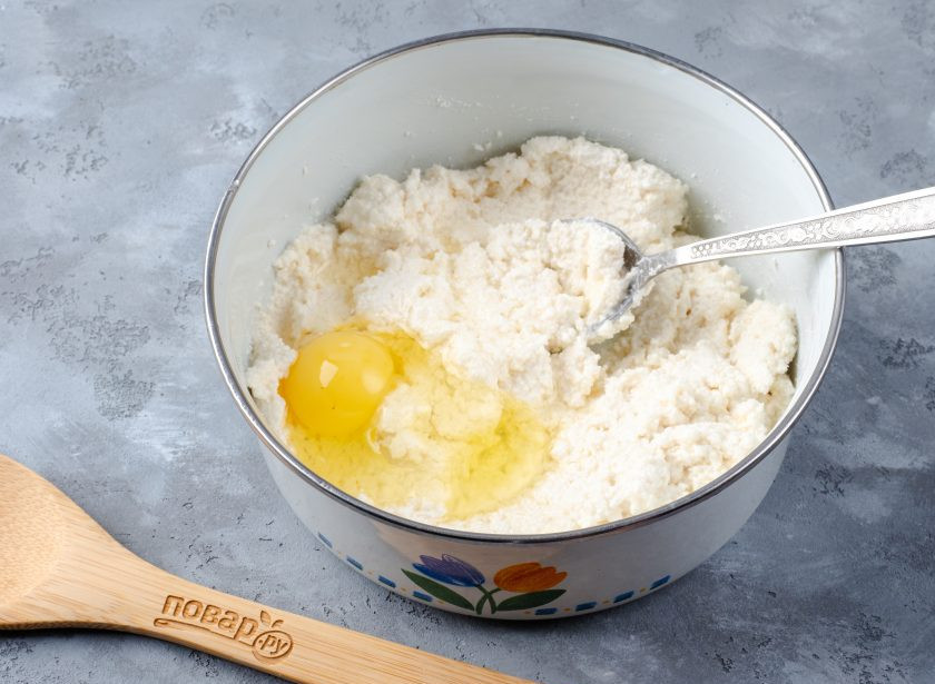 1. Этап. Сырники из обезжиренного творога: Добавьте яйцо и щепотку соли. Перемешайте.