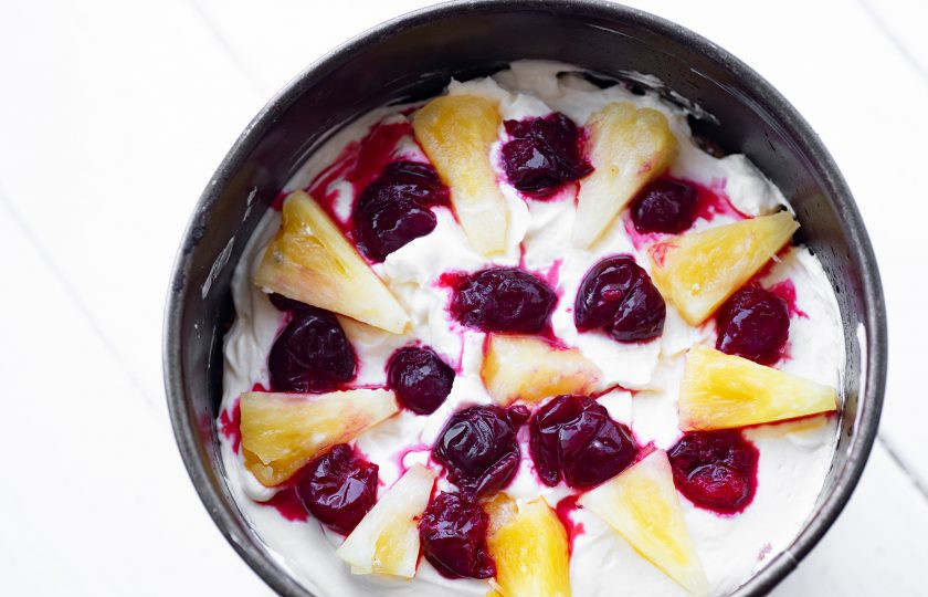 1. Этап. Торт с вишней и ананасом: Поверх выложите следующий бисквитный корж, пропитайте сиропом, распределите слоем крем, поверх разложите кусочки ананаса и вишни в произвольном порядке. Поверх накройте оставшимся бисквитным коржом, форму затяните пищевой пленкой и оправьте собранный тортик на ночь в холодильник пропитываться.