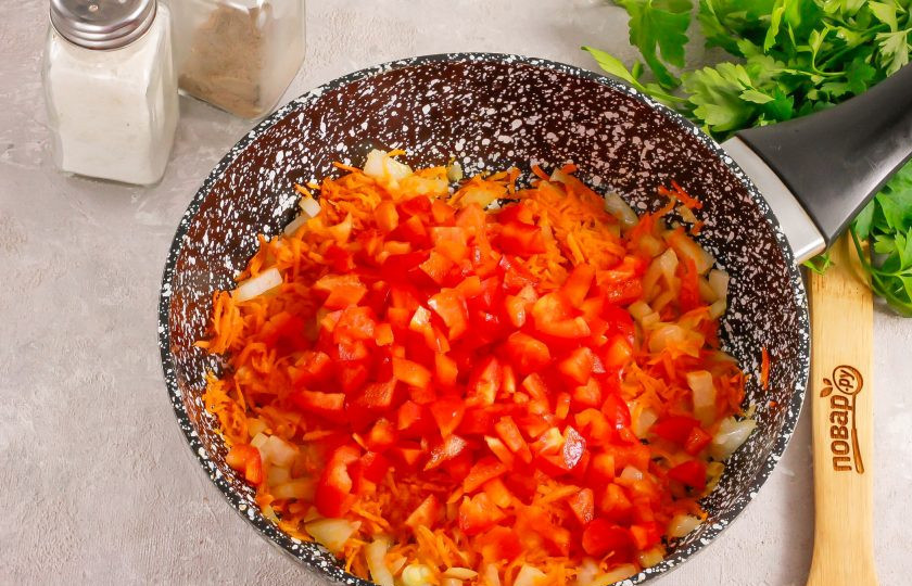 1. Этап. Подлива из лука, моркови, сладкого перца и томата: Перец нарежьте мелкими кубиками и добавьте его к другим овощным нарезкам на сковороде.