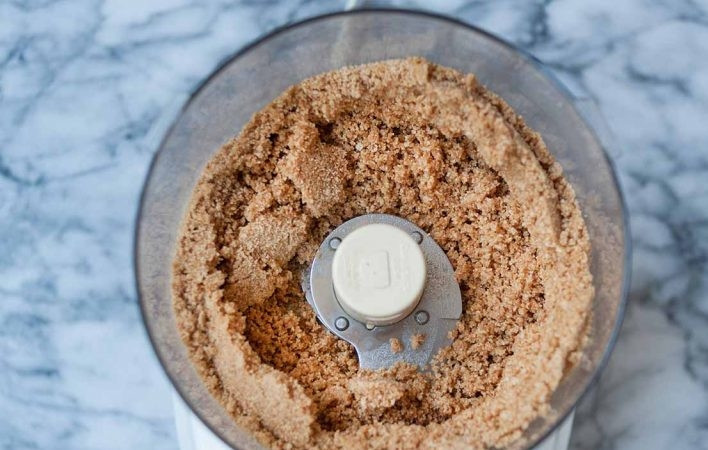 1. Этап. Ванильный чизкейк без выпечки: 3. Растопите сливочное масло и добавьте его в чашу к измельченным крекерам.