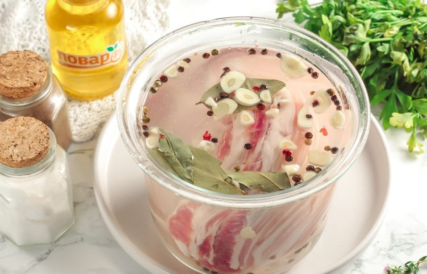 1. Этап. Бекон в домашних условиях: Влейте фильтрованную воду и тщательно перемешайте, чтобы растворилась соль. Промойте грудинку, сделайте сквозные прорезы ножом и выложите в рассол. Главное условие — рассол должен покрывать мясо полностью. Поместите емкость в холодильник.