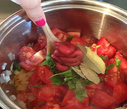 1. Этап. Кальмары в томатном соусе: 5. Рецепт приготовления кальмаров в томатном соусе довольно прост. На сковороду налить немного растительного масла и разогреть. Отправить туда лук, и обжарить на среднем огне до прозрачности. Затем добавить чеснок, помидоры и базилик. Для более яркого цвета соуса можно отправить туда немного томатной пасты. Посолить и поперчить по вкусу. Все тщательно перемешать и сверху выложить 1-2 лавровых листка.