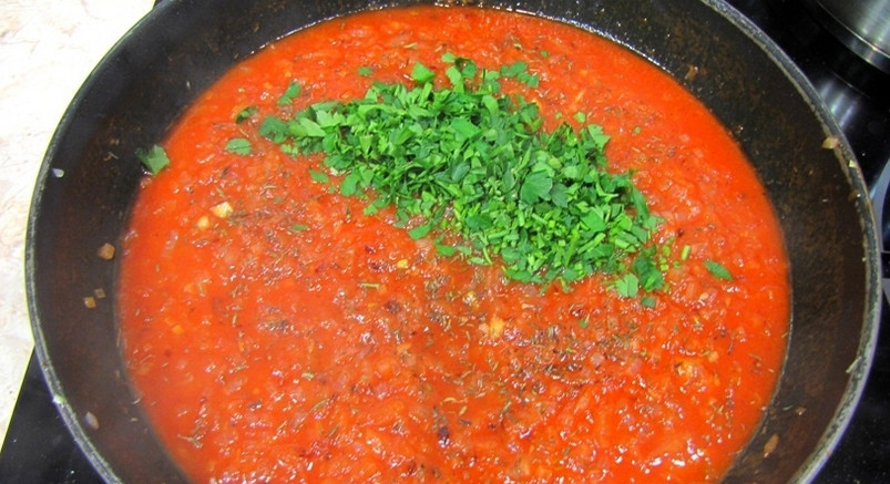 1. Этап. Рыбные котлеты под соусом в духовке: 3. Теперь займёмся приготовлением соуса: для этого обжарим оставшийся лук, добавим к нему зелень и томатную пасту. Специи — по вкусу. Ждем, пока, не закипит.