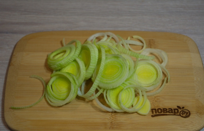 1. Этап. Азиатский куриный суп: Лук-порей нарежьте тонкими колечками. После нарезки промойте лук под проточной водой и дайте стечь жидкости. Поступаем именно так, ибо внутри стебля могут оставаться частички песка.