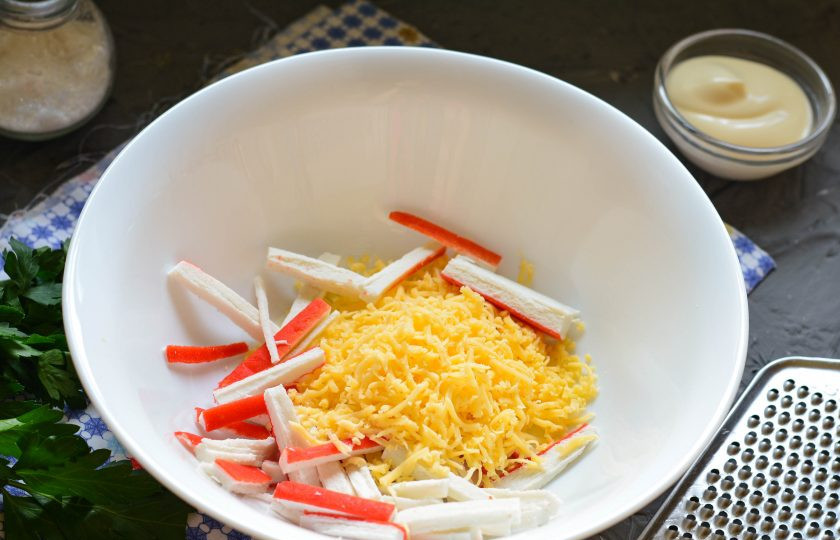 1. Этап. Салат «Дипломат» с крабовыми палочками: Натрите твердый сыр на мелкой терке и соедините с палочками.