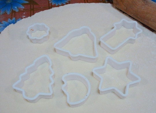 1. Этап. Рождественское печенье из творога: 3. Готовому тесту дайте полежать минут 10. За это время подготовьте противни для выпекания, застелите их пергаментом или фольгой. Тесто после раскатайте, присыпав рабочий стол мукой, формами вырежьте печенюшки.