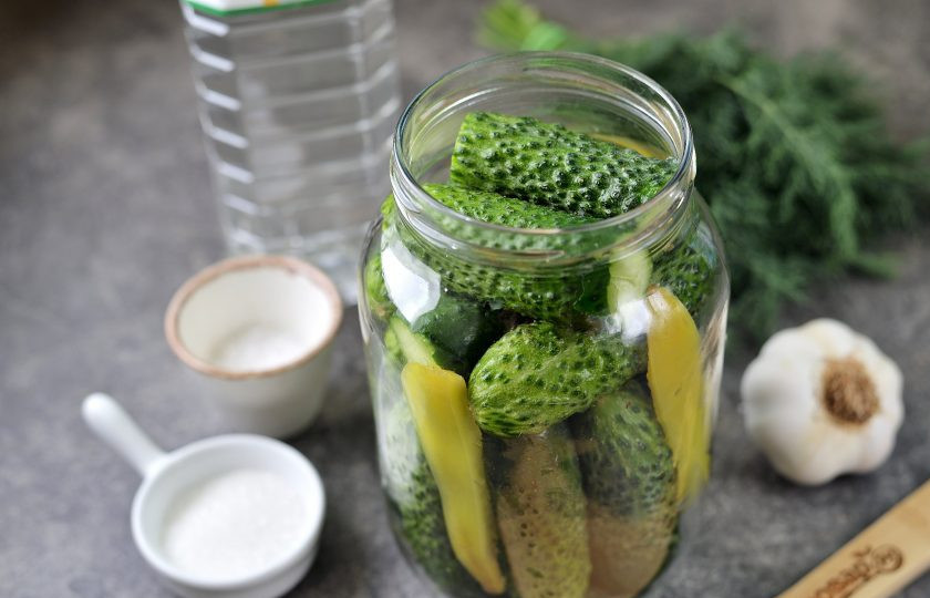 1. Этап. Огурцы маринованные Любимые: Срежьте хвостики на огурцах, со стороны надреза посередине проколите огурцы вдоль зубочисткой, это поможет им быстрее мариноваться. Наполните банку огурцами до верха, выложите пару ломтиков болгарского перца для аромата.