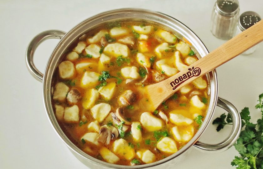 1. Этап. Грибной суп с галушками: В кипящую воду опустите картофель, дождитесь закипания и добавьте галушки. Добавьте по вкусу специи, соль и варите 10-15 минут до полной готовности всех ингредиентов. За 5 минут до окончания варки, добавьте обжаренные овощи с грибами. Когда грибной суп с галушками будет готов, добавьте измельченную свежую зелень. Дайте супу настояться 15-20 минут и подавайте к столу.