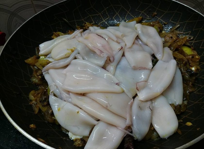 1. Этап. Бэби-кальмары с зелеными помидорами: 5. Поместите кальмары в сковороду с тушеными помидорами, готовьте их до мягкости.