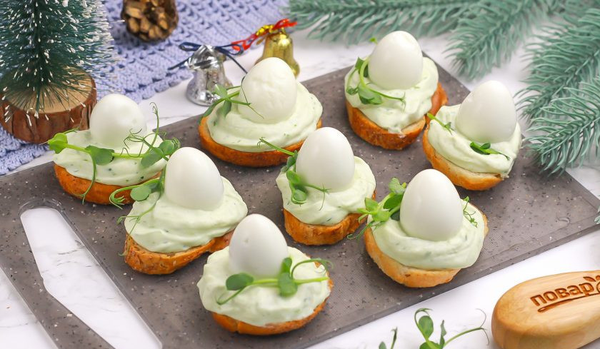 1. Этап. Канапе Яйца змеи: Выложите на каждый ломтик отварное перепелиное яйцо. По желанию можете украсить еще зеленью или приправами, специями.