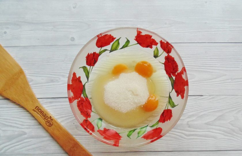 1. Этап. Медовый торт с вишней: Насыпьте к яйцам сахар.