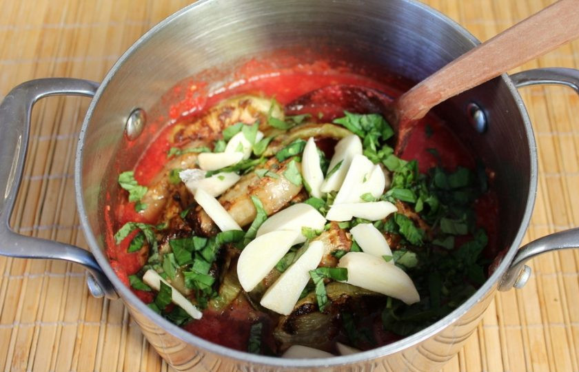 1. Этап. Жареные баклажаны в томатном соусе на зиму: Добавляем базилик и чеснок. Ставим на огонь и кипятим 5 -7 минут.