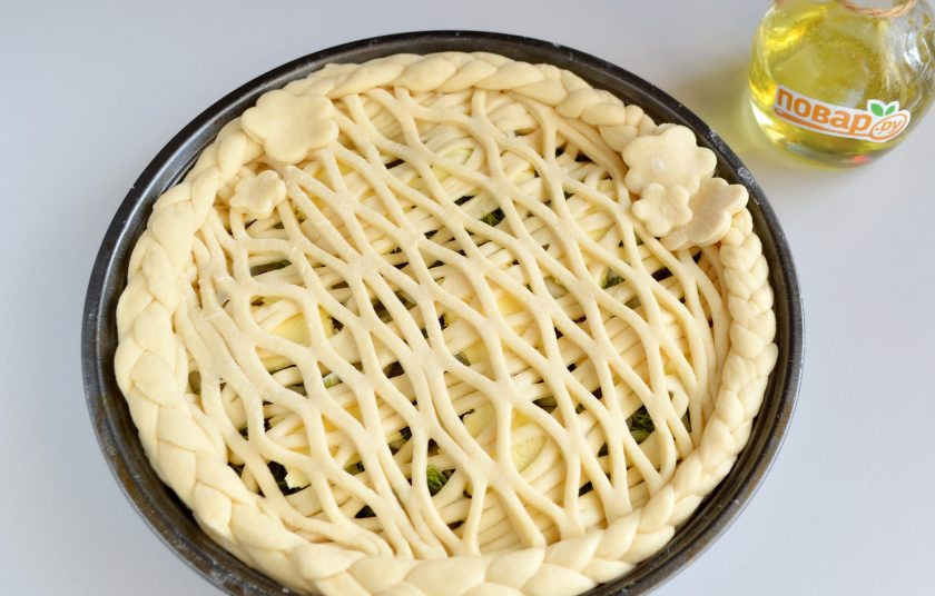 1. Этап. Пирог с мойвой и укропом: 9. Из второй половины теста сделайте верхушку и украшение для пирога. Я положила два слоя сеточки из теста, по кругу - плетенные косички, в месте стыка - цветочки.