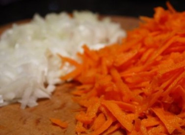 1. Этап. Салат с курицей и черносливом слоеный: Чистим лук и морковь. Морковь натираем на терке, лук нарезаем кубиками.