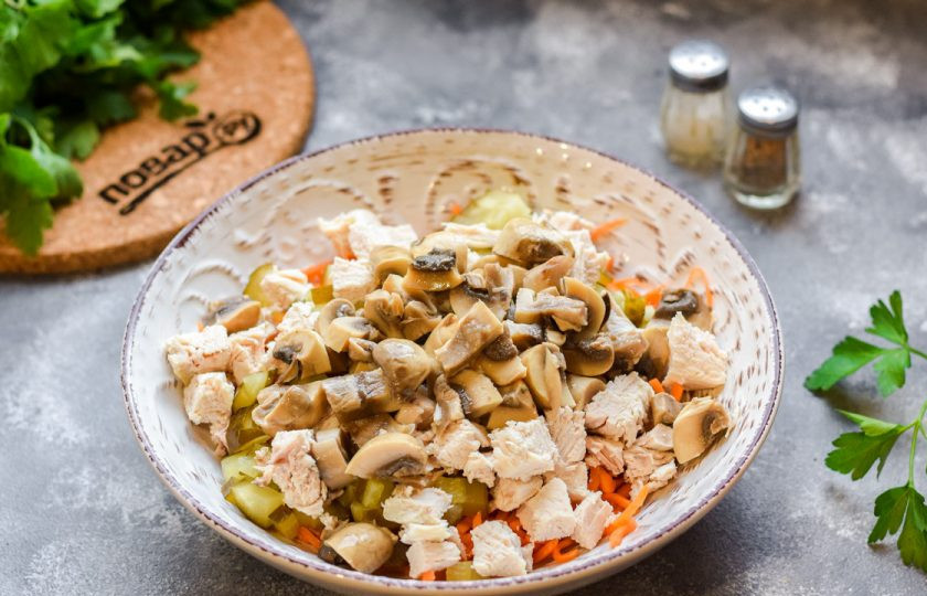 1. Этап. Салат с курицей и маринованными шампиньонами: Маринованные шампиньоны нарежьте небольшими кусочками и добавьте в салат.