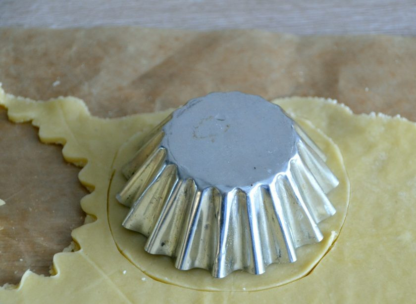 1. Этап. Пирожное Корзиночка с масляным кремом: Вырежьте кружочки из теста и распределите его по формочкам. Чтобы готовые корзиночки легко извлекались, смажьте формочки сливочным маслом и слегка присыпьте мукой.