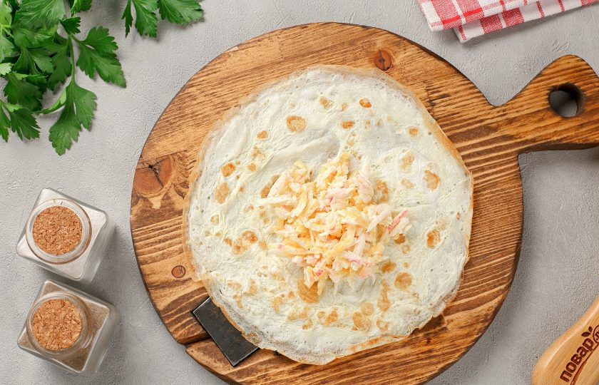 1. Этап. Яичные блинчики с крабовыми палочками и сыром: На каждый готовый блинчик по центру выложите немного начинки.