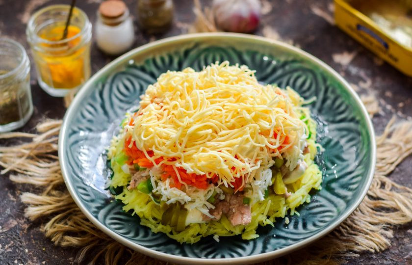 1. Этап. Салат из печени трески слоеный: Выложите следом слой твердого сыра, натертого мелкой стружкой.