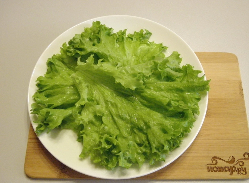 1. Этап. Салат с брокколи и курицей: Возьмите порционные тарелочки, разложите листья салата. Из данного количества продуктов выходит две хорошие порции.