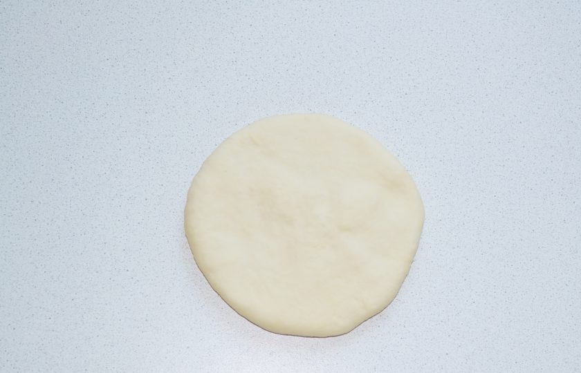 1. Этап. Хычины на кефире: Раскатайте лепешку, чтобы начинка распределилась равномерно.