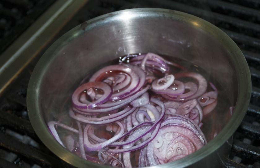 1. Этап. Медальоны из телятины: Когда из вина выпарится весь алкоголь, добавляем в него нарезанный кольцами красный лук.