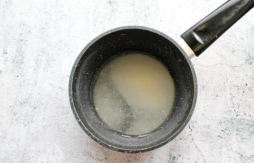 1. Этап. Настойка на косточках вишни: В кастрюле с толстым дном смешайте сахар и воду. Доведите все до кипения и варите на среднем огне в течение 3 минут. Снимите кастрюлю с огня и остудите.