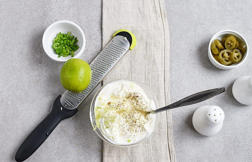 1. Этап. Сметанный соус к рыбе: Добавьте сок и цедру половинки лайма и снова перемешайте.
