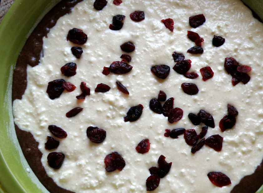 1. Этап. Пирог «ТвороШок»: В хорошо смазанную форму вылейте треть шоколадного теста. Распределите сверху творожную начинку и посыпьте ее вяленой клюквой. Вылейте сверху остаток шоколадного теста.