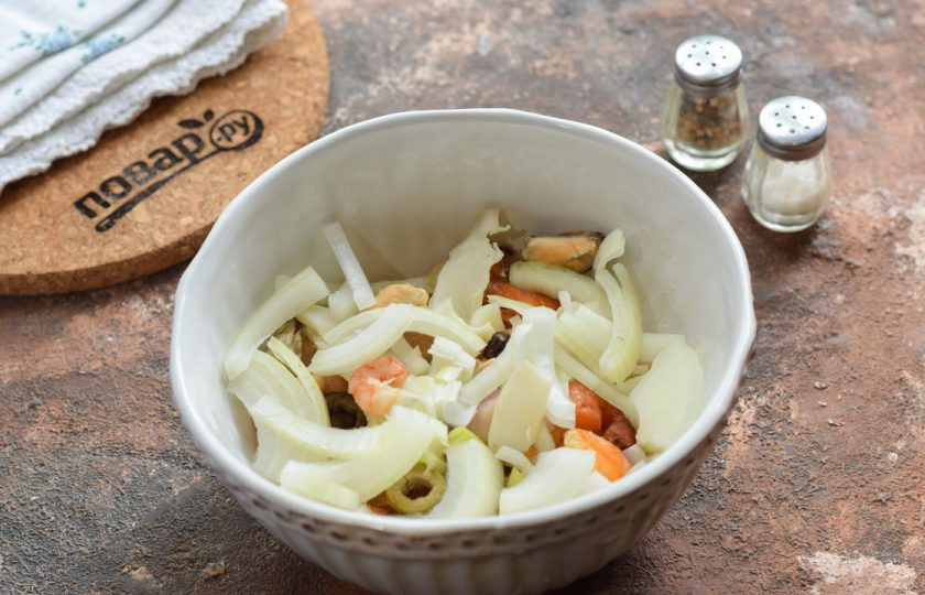 1. Этап. Салат с фасолью и морепродуктами: Очистите лук, нарежьте тонкими полосками и добавьте в салат.