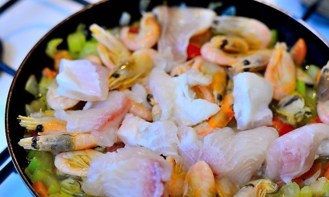 1. Этап. Чиопино: 8. Мидии, креветки и филе рыбы выложите к овощам, залейте бульоном. Доведите до кипения и накройте крышкой. Оставьте на среднем огне.