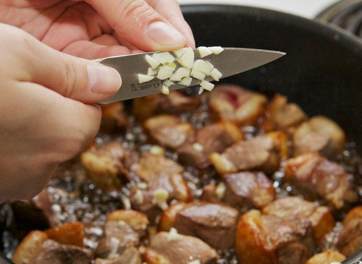 1. Этап. Тушенная утка с баклажанами и картофелем: Уменьшите огонь и порежьте в сковороду чеснок.