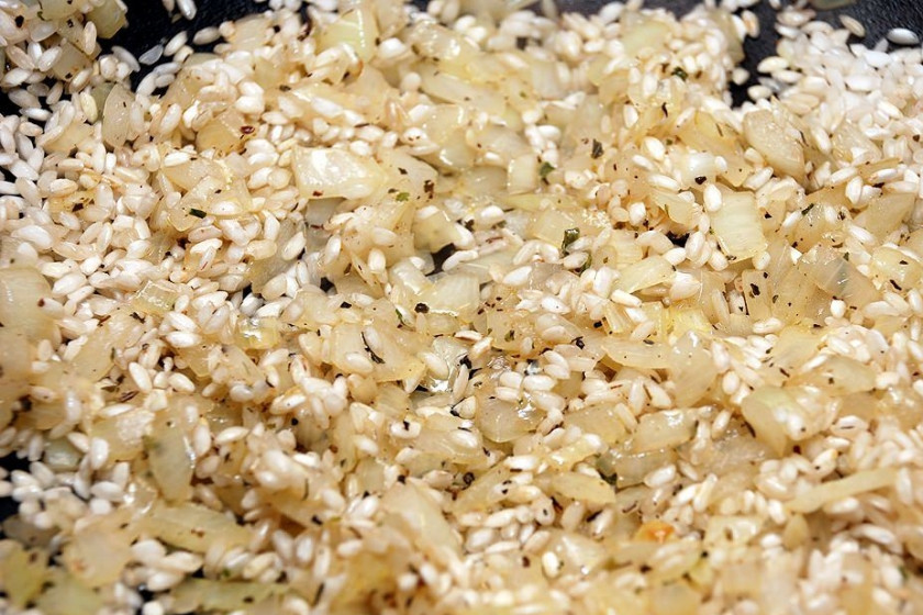 1. Этап. Ризотто с индейкой: Засыпаем к луку рис, обжариваем его, помешивая, пока он не приобретет жемчужный оттенок. Затем вливаем вино и даем ему испариться, чуть увеличив огонь.