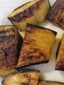 1. Этап. Баклажан, тушёный в остром соусе: В глубокой ёмкости разогреть 2 столовые ложки масла и жарить баклажаны мякотью вниз 2 минуты, затем перевернуть и жарить ещё 2 минуты до полуготовности. Отложить в сторону.