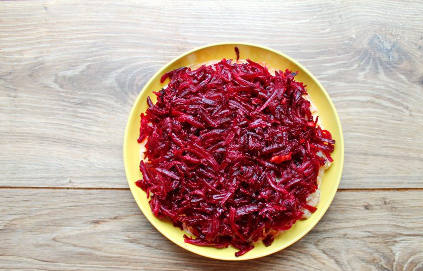 1. Этап. Селёдка под шубой с двумя видами рыбы: Отварную свеклу натрите на средней или крупной терке и полностью покройте салат ровным слоем. Смажьте свекольный слой майонезом.