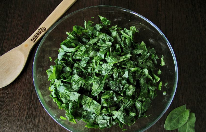 1. Этап. Заливной пирог с щавелем: Добавьте щепотку соли и помните щавель руками, чтобы он стал мягче и его было удобнее использовать для начинки.