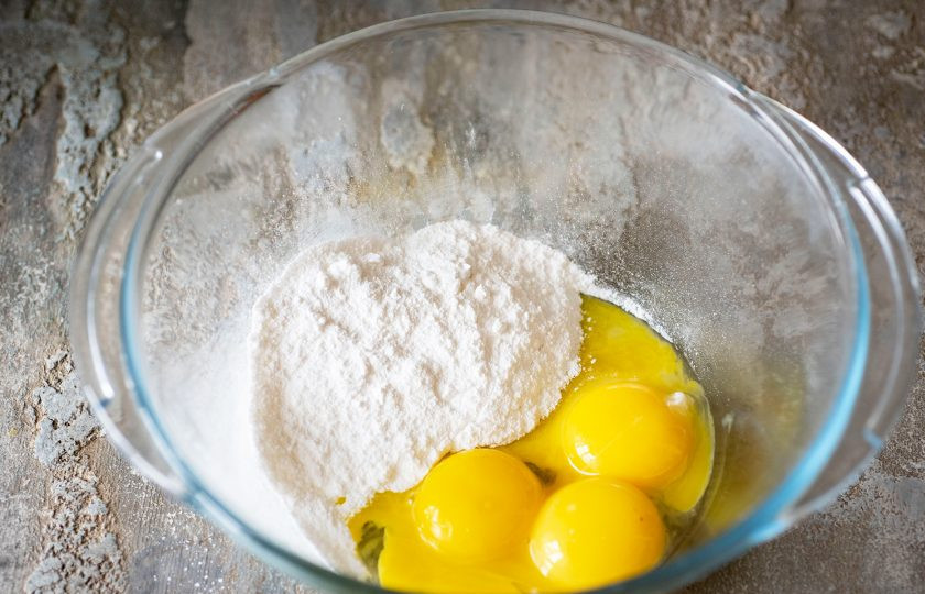 1. Этап. Черный бисквит: В просторную миску выложим все желтки и добавим сахарную пудру.