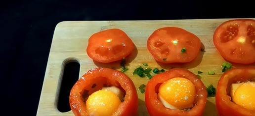 1. Этап. Запечённые помидоры с яйцом и сыром: Нарежьте 1/3 пучка зеленого лука. Вложите в каждый помидор горсть нарезанного зеленого лука и по кусочку сыра. Разбейте по одному яйцу в каждый помидор. Посыпьте каждый помидор щепоткой соли и черного перца. Натрите 100 г сыра на терке и посыпьте помидоры сверху.