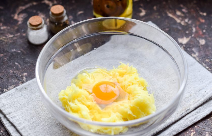 1. Этап. Колдуны из картофеля и мясного фарша: Картофель очистите, натрите на мелкой терке, немного отожмите жидкость. Добавьте к картофелю одно крупное куриное яйцо.