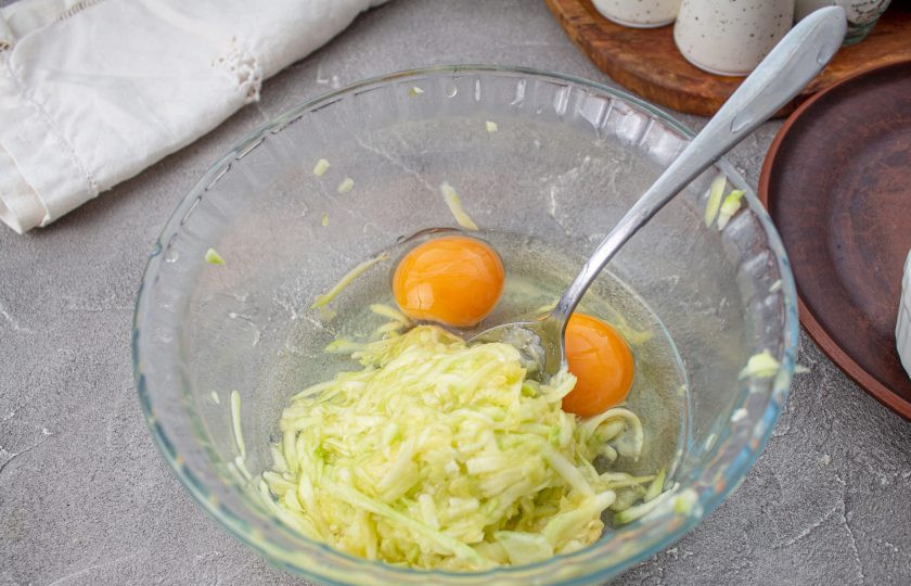 1. Этап. Кето-вафли из кабачков: Вбейте куриные яйца, перемешайте.