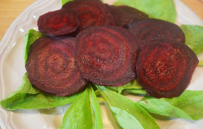 1. Этап. Лосось со свеклой и беконом: 6. На тарелку выложите листья шпината и кружки свеклы.