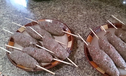 1. Этап. Aдана кебаб: Замочите длинные деревянные шпажки в воде. Затем нанизывайте на них фарш, придавая ему вид продолговатой котлетки.