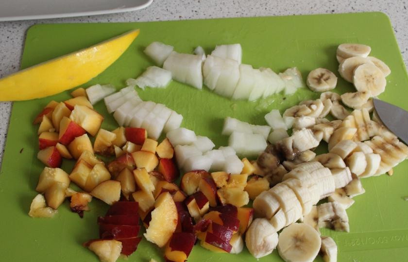 1. Этап. Фруктовый салат с дыней: Бананы очищаем, Разрезаем вдоль на две части и достаточно мелко режем поперек. Персики разрезаем по палам и достаем косточки, размельчаем. Кубиками нарезаем дыню. Раскладываем по тарелкам.