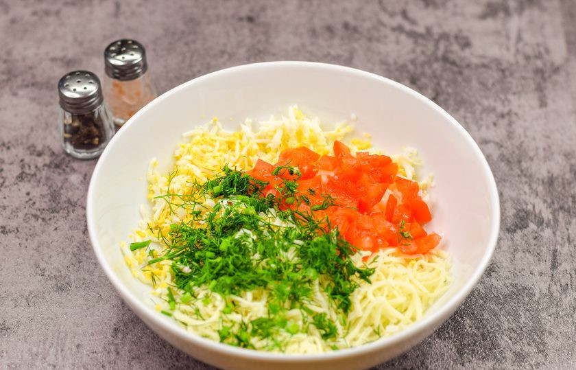 1. Этап. Пикантная закуска на чипсах: Помидор ополосните и просушите, удалите сердцевину, так как она даст лишнюю жидкость. Стенки помидора нарежьте кубиком и переложите в салат. Укроп сполосните и просушите, нарежьте мелко и добавьте ко всем ингредиентам.