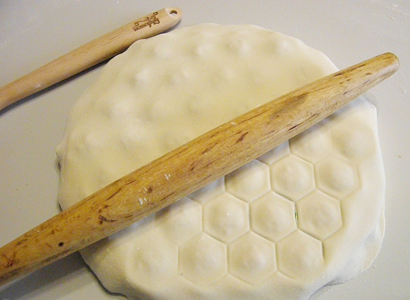 1. Этап. Пельмени с сыром в духовке: Раскатайте второй лист теста. Накройте ним пельменницу. Присыпьте сверху мукой, скалкой пройдитесь по пельменнице.