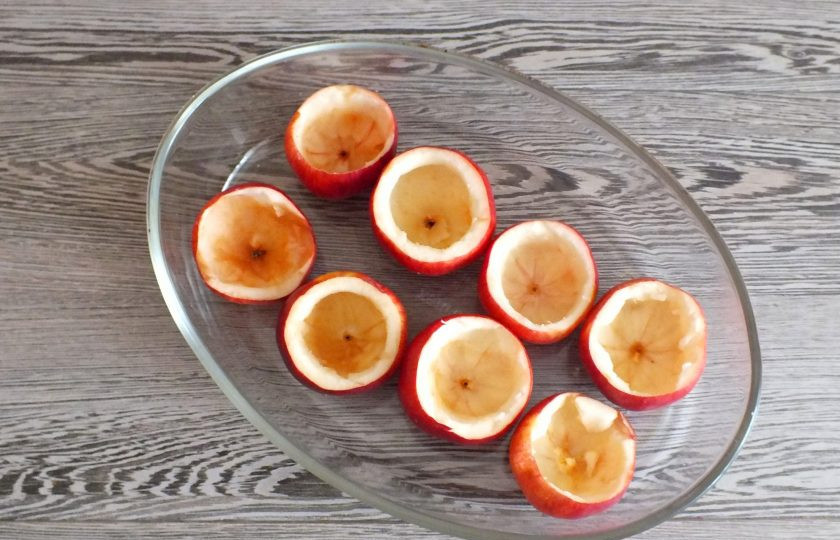 1. Этап. Яблоки запеченные с творогом, орехами и мёдом: Яблоки вымойте. Срежьте верхушку. С помощью ложки или ножа удалите мякоть, оставив небольшое количество на стенках и донышке яблока. Выложите подготовленные яблоки в жаропрочную посуду.