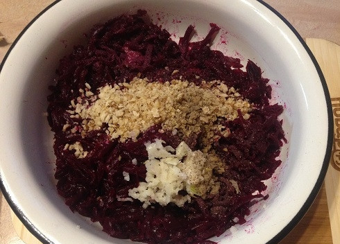 1. Этап. Свекольный салат с чесноком и орехами: Добавляем к свекле измельченные орехи и чеснок, соль и черный молотый перец.