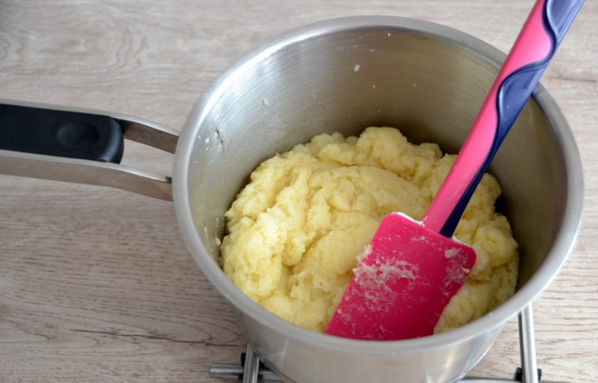 1. Этап. Профитроли с масляным кремом: Тесто должно собраться в комок и отставать от стенок. Снимите с огня, слегка охладите.