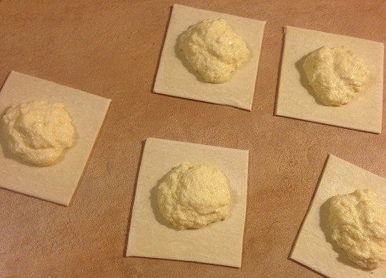 1. Этап. Венгерские ватрушки с творогом: Тесто слегка раскатаем и нарежем на квадраты. Стороны квадратов должны быть не меньше 10 см. В центр каждого выкладываем творожную начинку. Уголки квадратов смажем желтком.